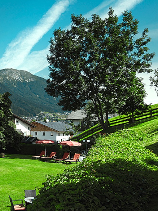 gay Bergwandern im Stubaital / Tirol - der Hotelgarten mit gemütlichen Sonnenliegen und traumhafter Bergsicht
